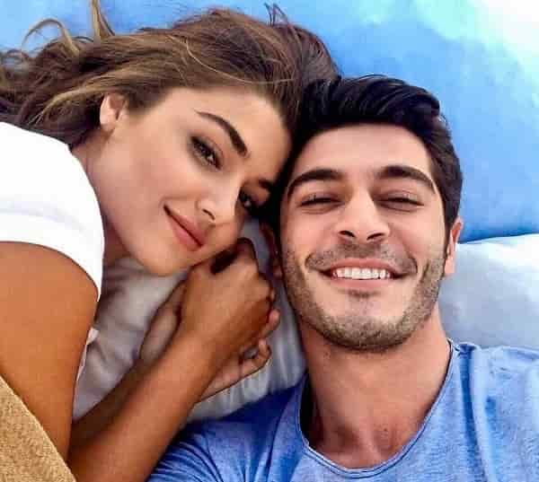 Hande Erçel İki Yabancı Two Strangers turkish drama series fox burak deniz 2023-min new turkish series Iki Yabanci featuring Hande Erçel wearing a white t-shirt sitting next to Burak deniz wearing a blue t-shit smiling