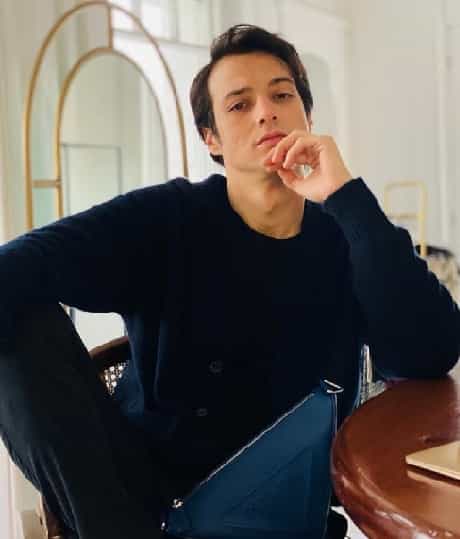 Turkish Actor Burak Özçivit Ignites Netflix with movie Berber Mert Yazıcıoğlu-min mert yazıcıoğlu wearing a blue navy blouse holding his hand under chin in new netflix turkish movie berber next to Burak Özçivit