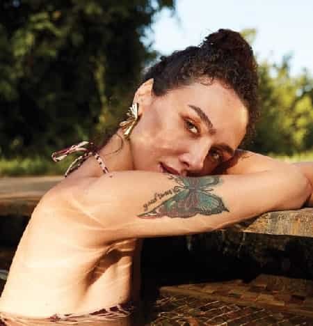 turkish actress of the netflix series Kuş Uçuşu, jack daniels birce akalay in a pool, with the butterflies tattoo and dark bun